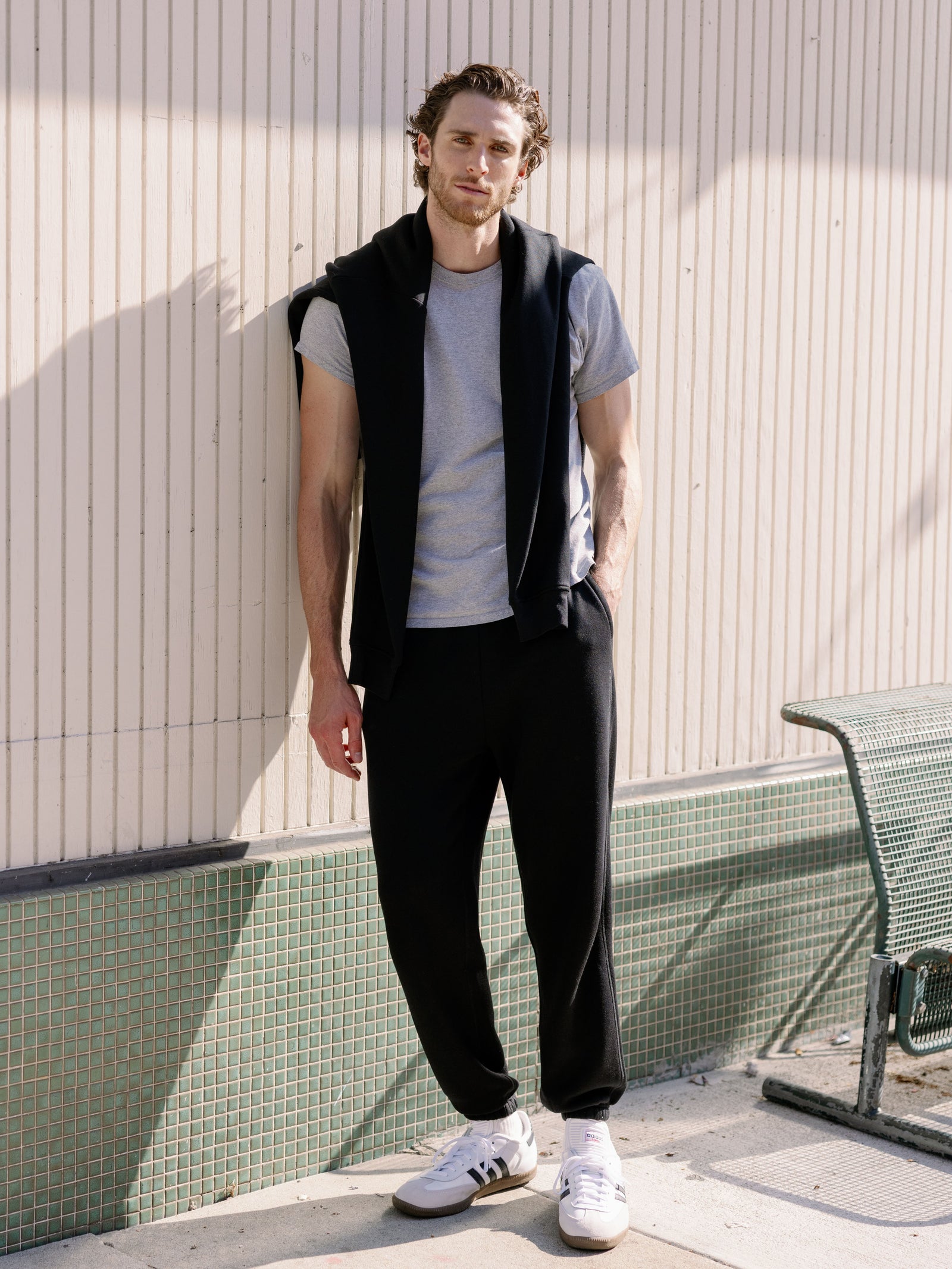 Man next to city wall wearing black cityscape sweats 