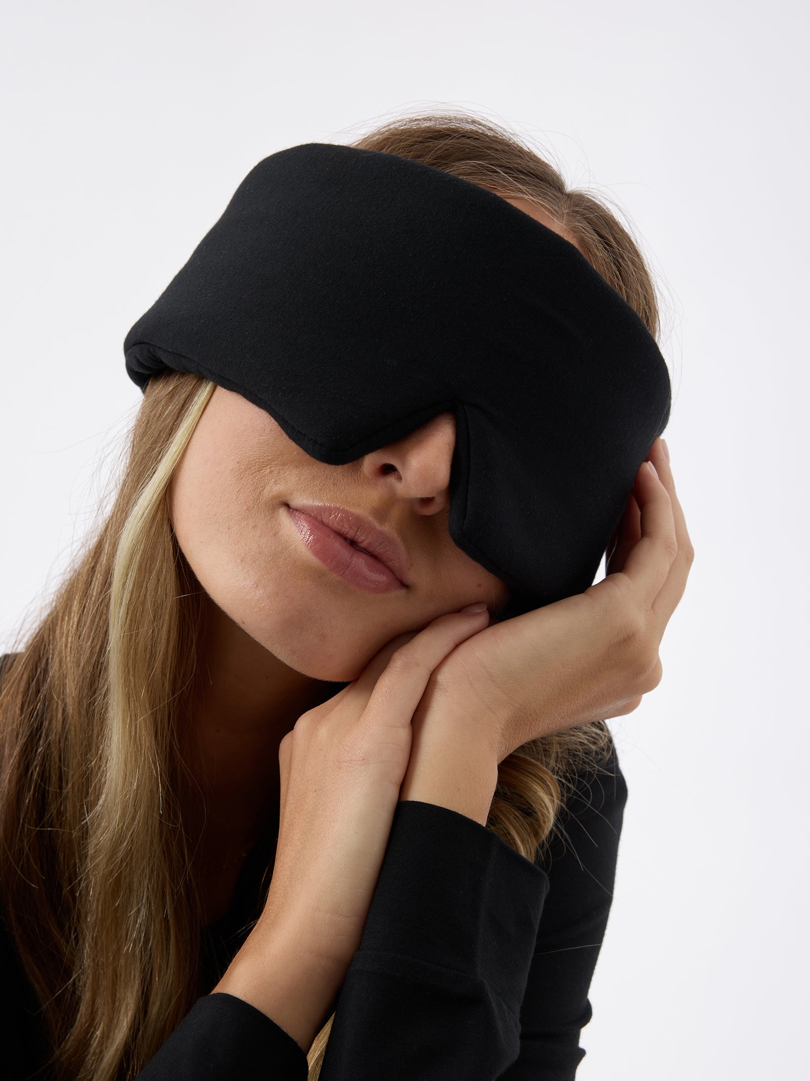 A woman wears the Cozy Earth Adjustable Bamboo Sleep Mask in Black. 
