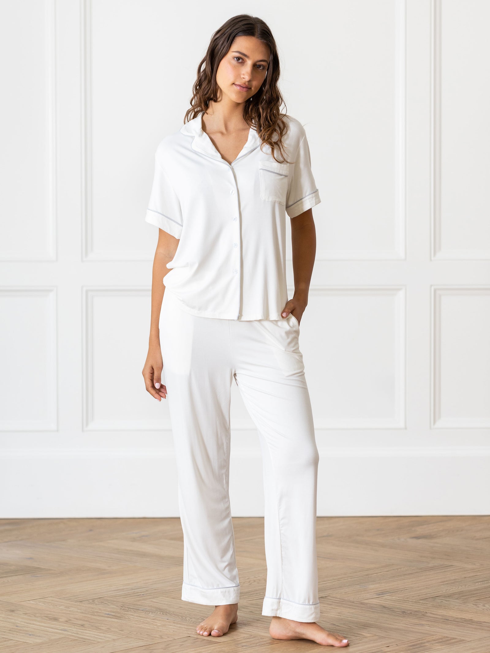 Ivory Short Sleeve & Pant Bamboo Pajama Set modeled by a woman. The photo was taken in a high contrast setting, showing off the colors and lines of the pajamas. 