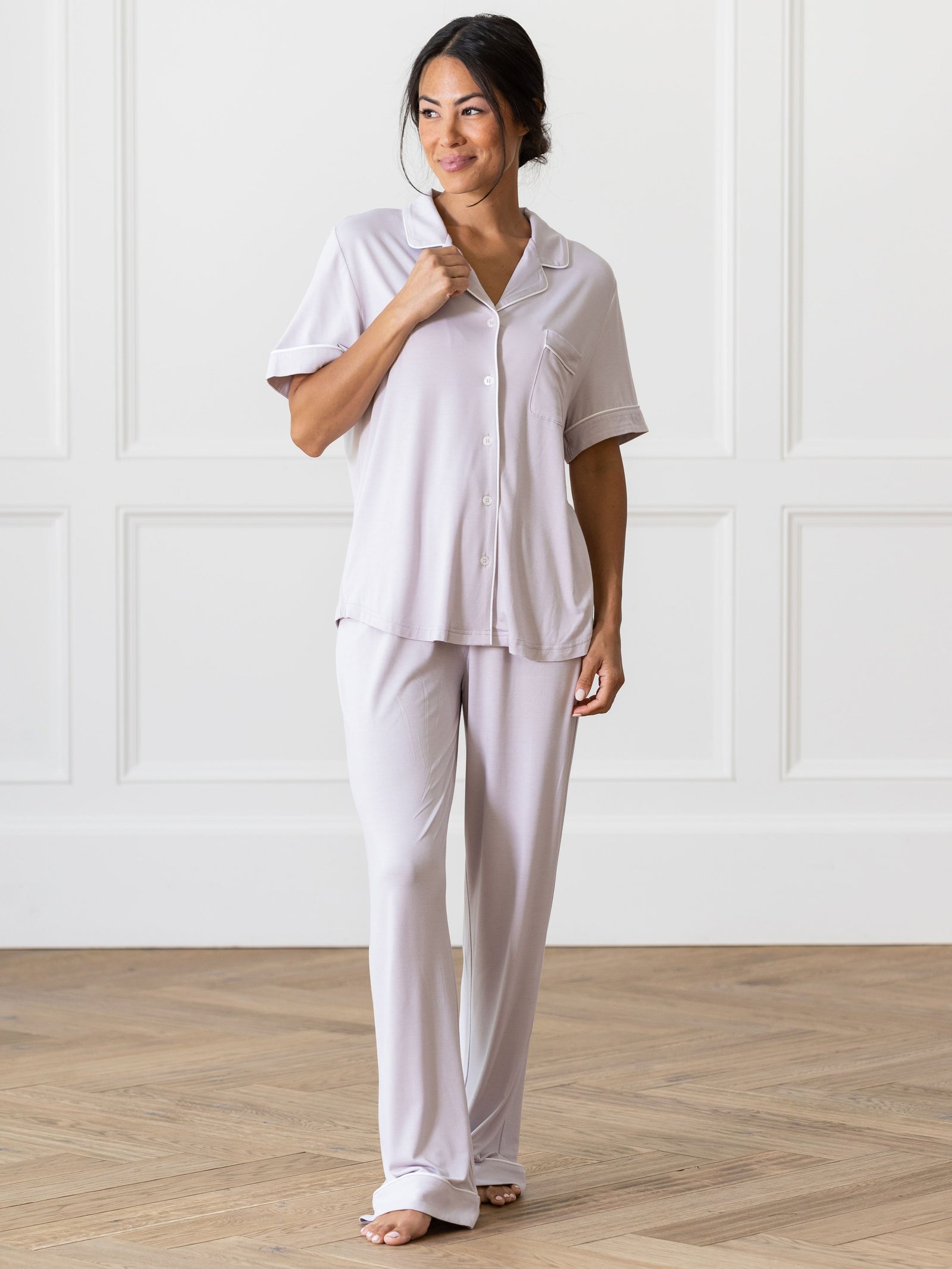 Lilac Short Sleeve & Pant Bamboo Pajama Set modeled by a woman. The photo was taken in a high contrast setting, showing off the colors and lines of the pajamas. 