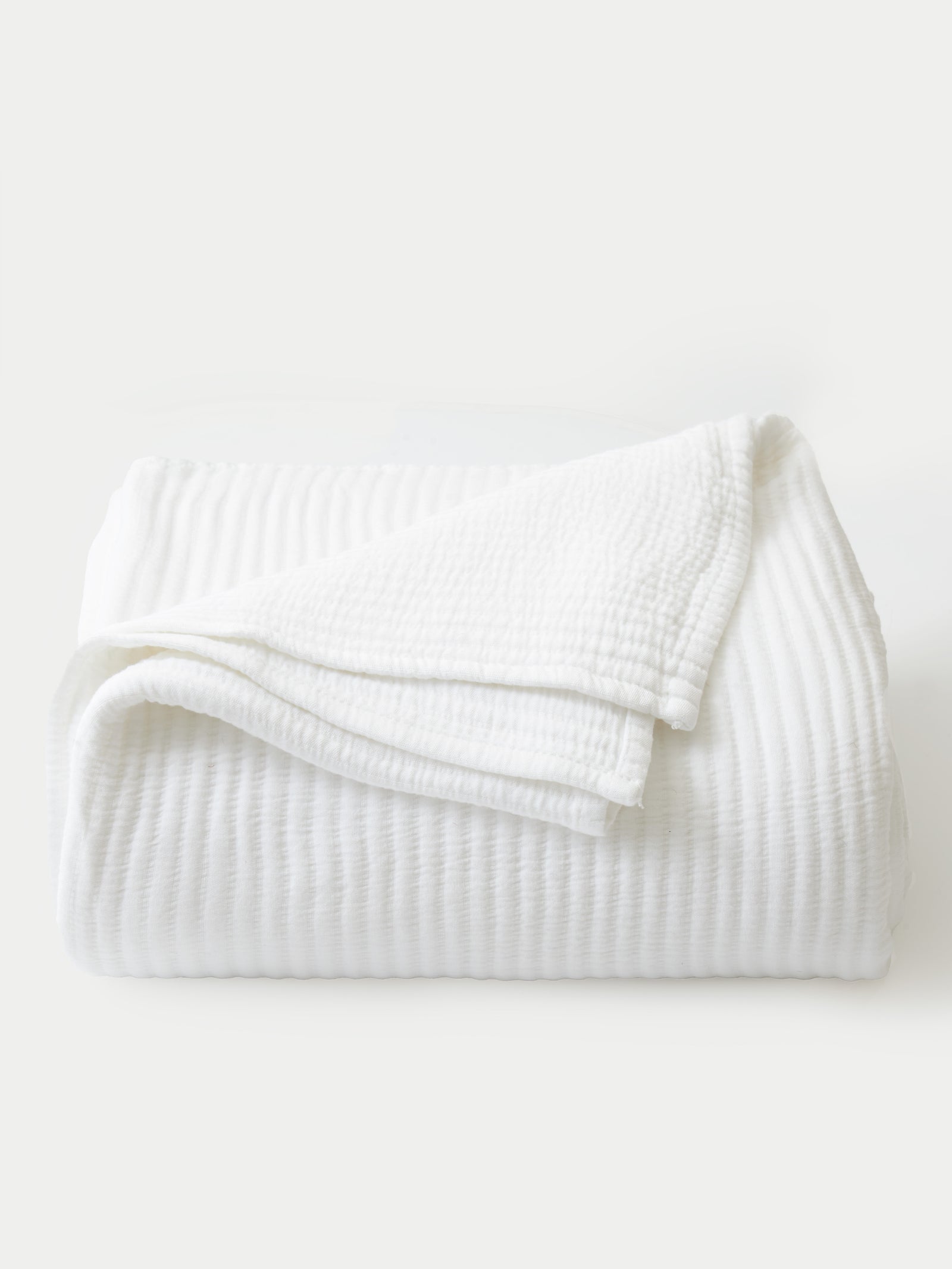 White coverlet folded with white background 