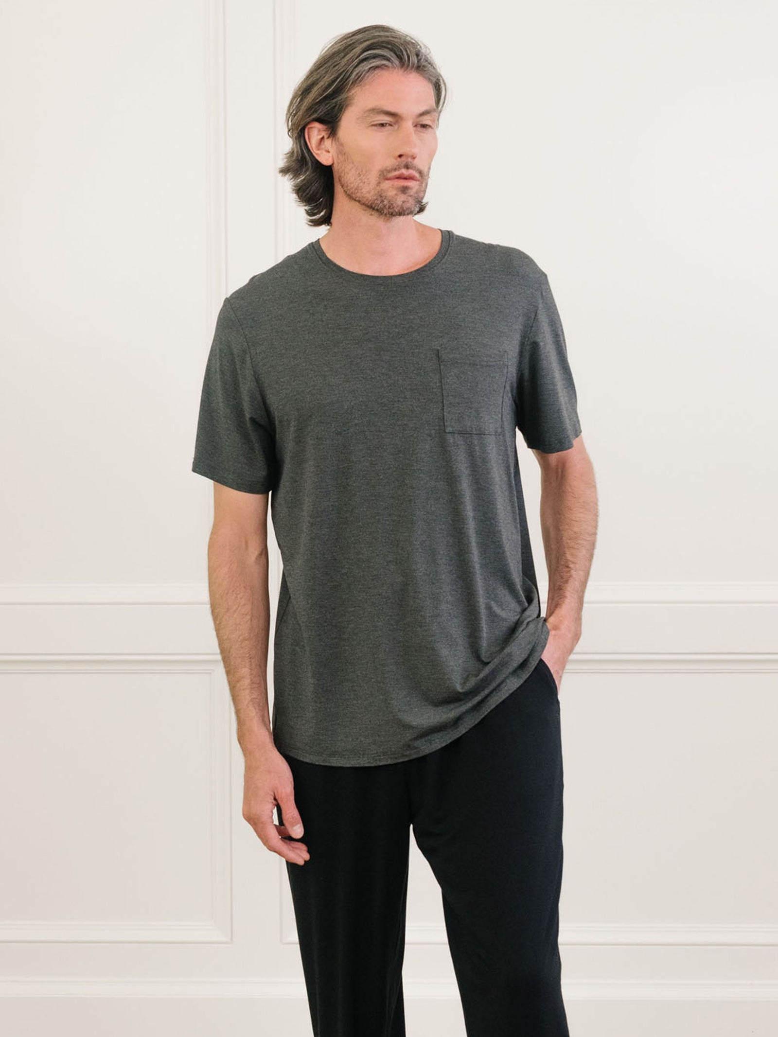 Charcoal Men's Stretch-Knit Bamboo Lounge Tee. A man is wearing the lounge tee in a well lit home.