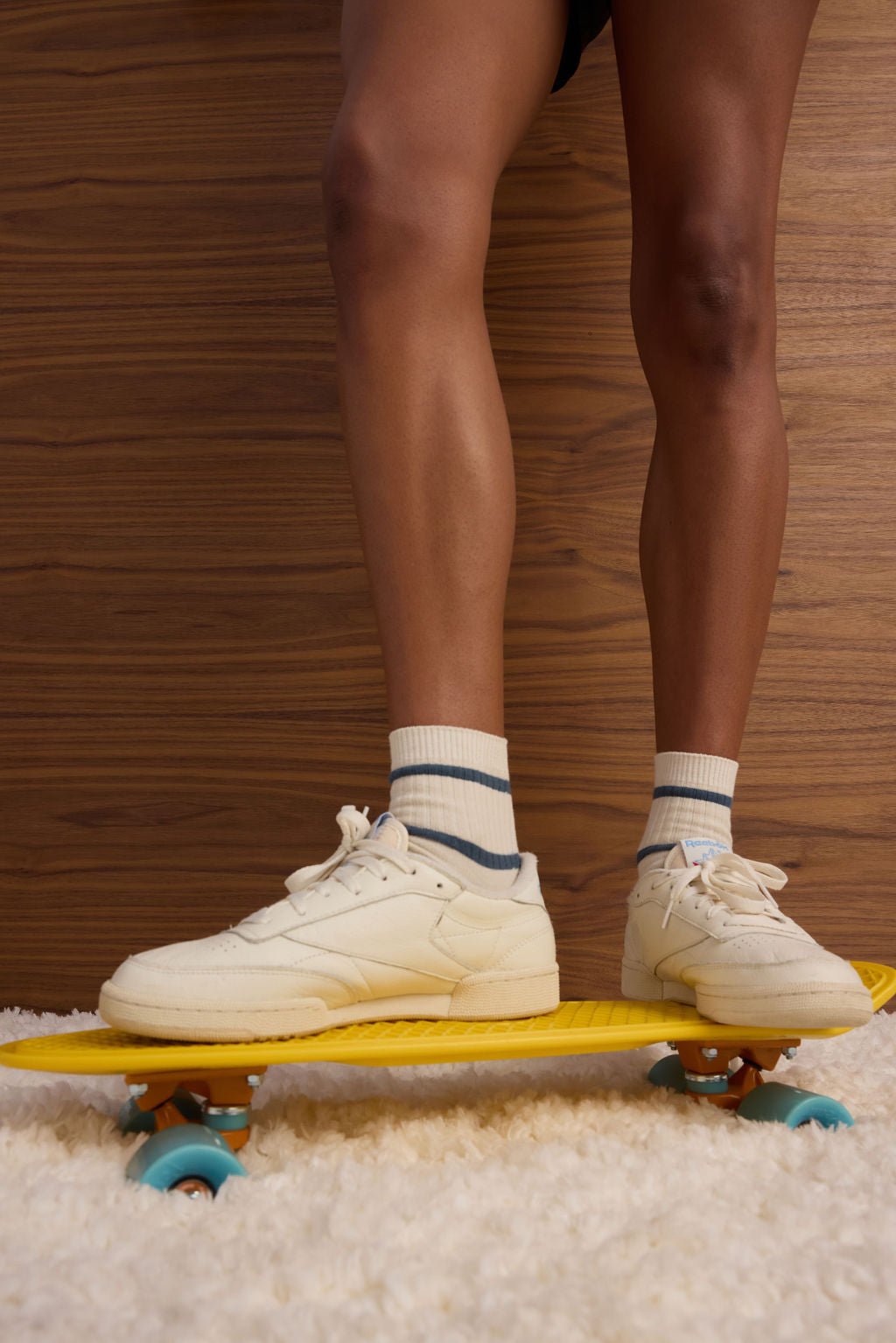 A person wearing Cozy Earth's Women's Sadie Sock in cream with dark blue stripes is shown on a skateboard. |Color:Mineral/Oceanside