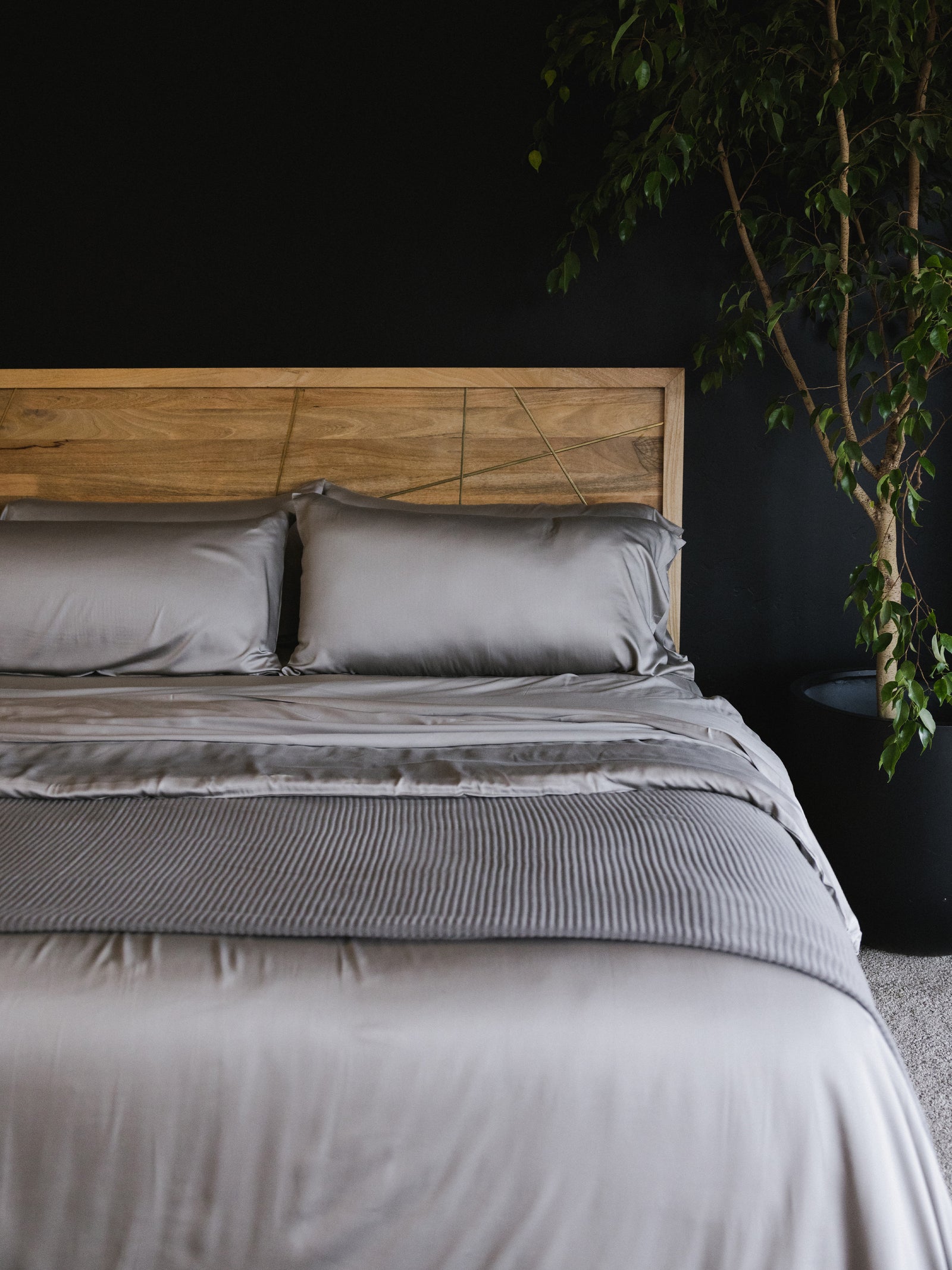 Dove Grey bedding on bed in room with dark walls 