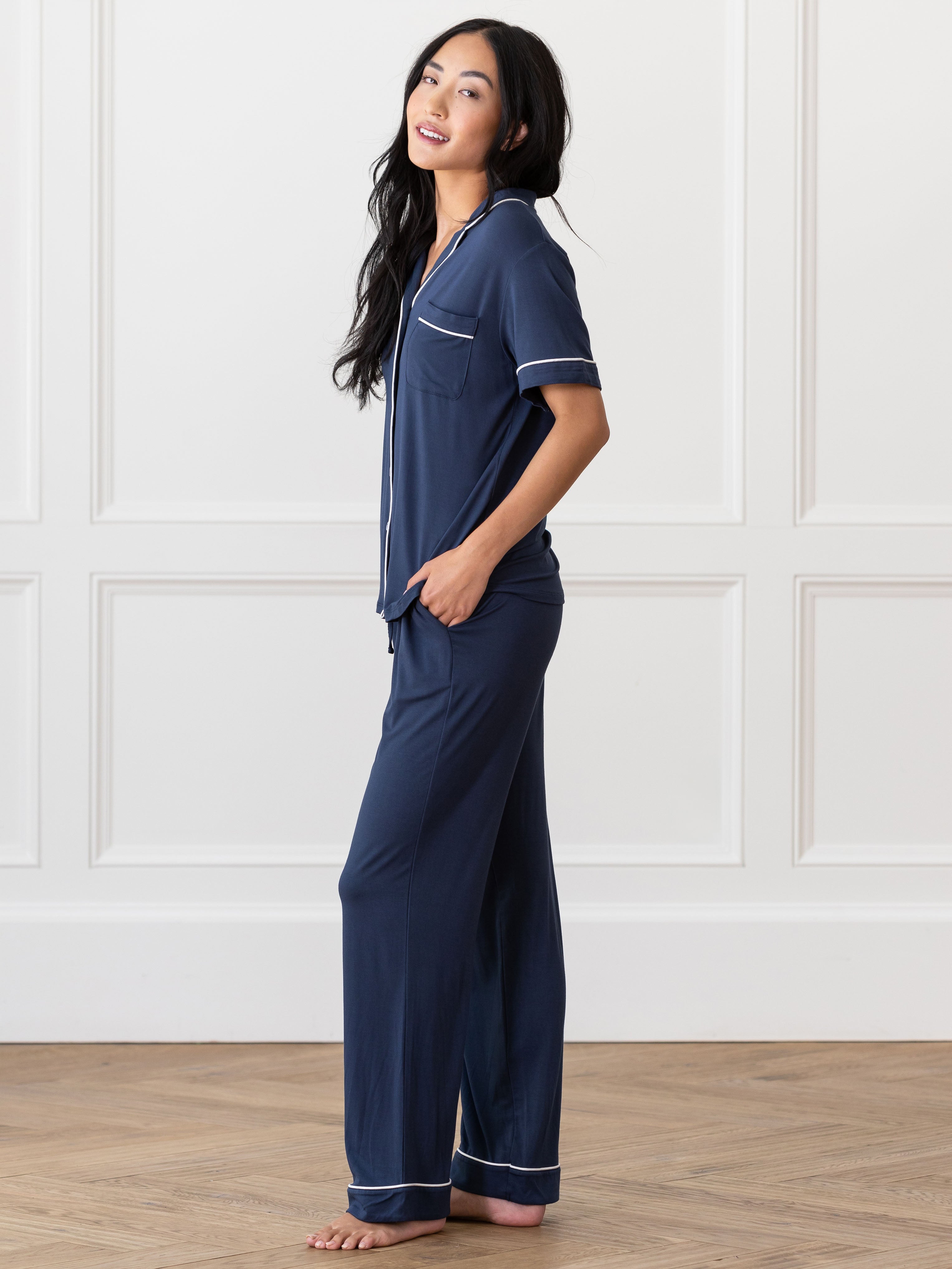 Navy Short Sleeve & Pant Bamboo Pajama Set modeled by a woman. The photo was taken in a high contrast setting, showing off the colors and lines of the pajamas. |Color: Navy