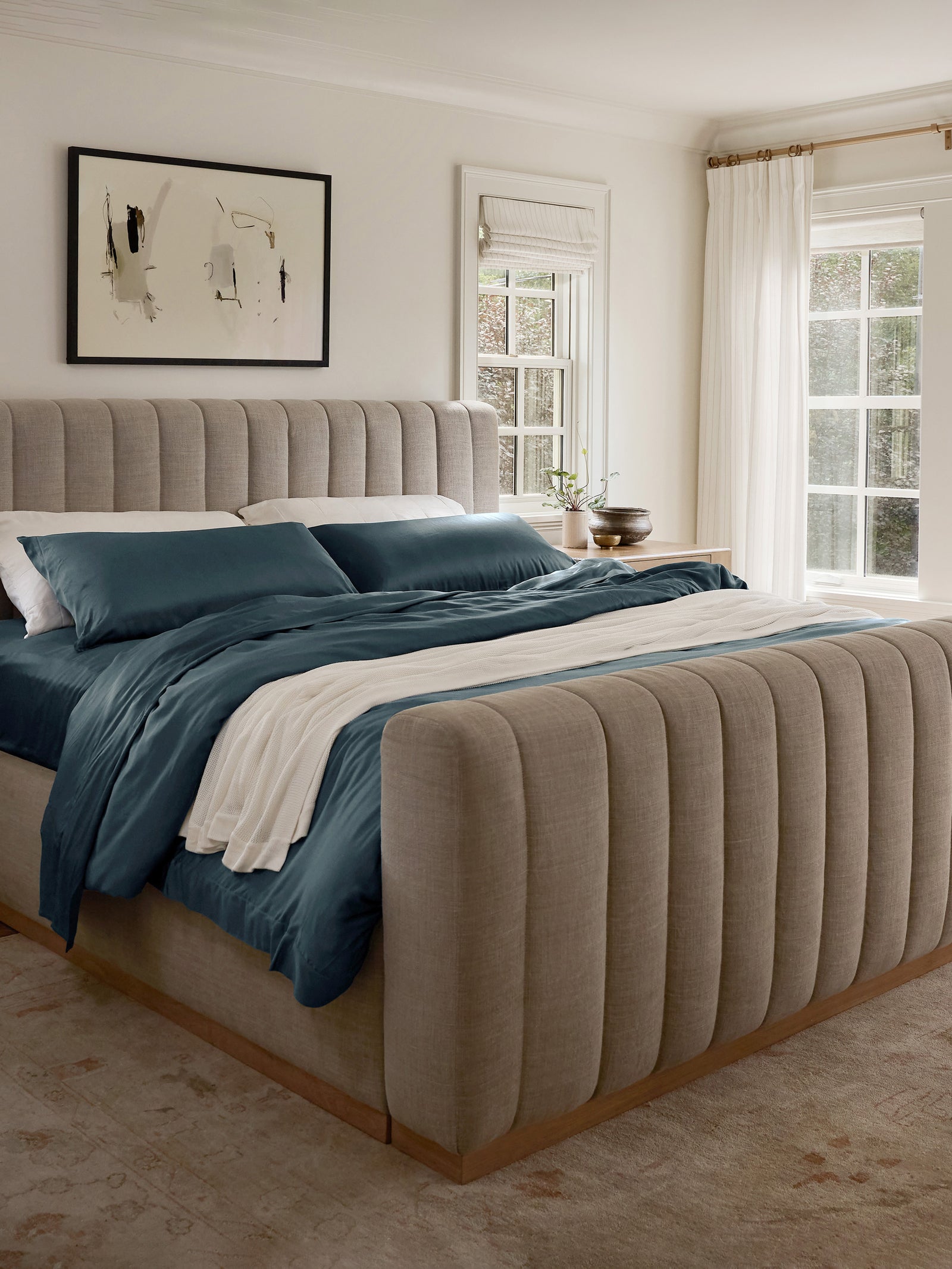 Zoomed out bedroom with bed with pacific blue bedding 