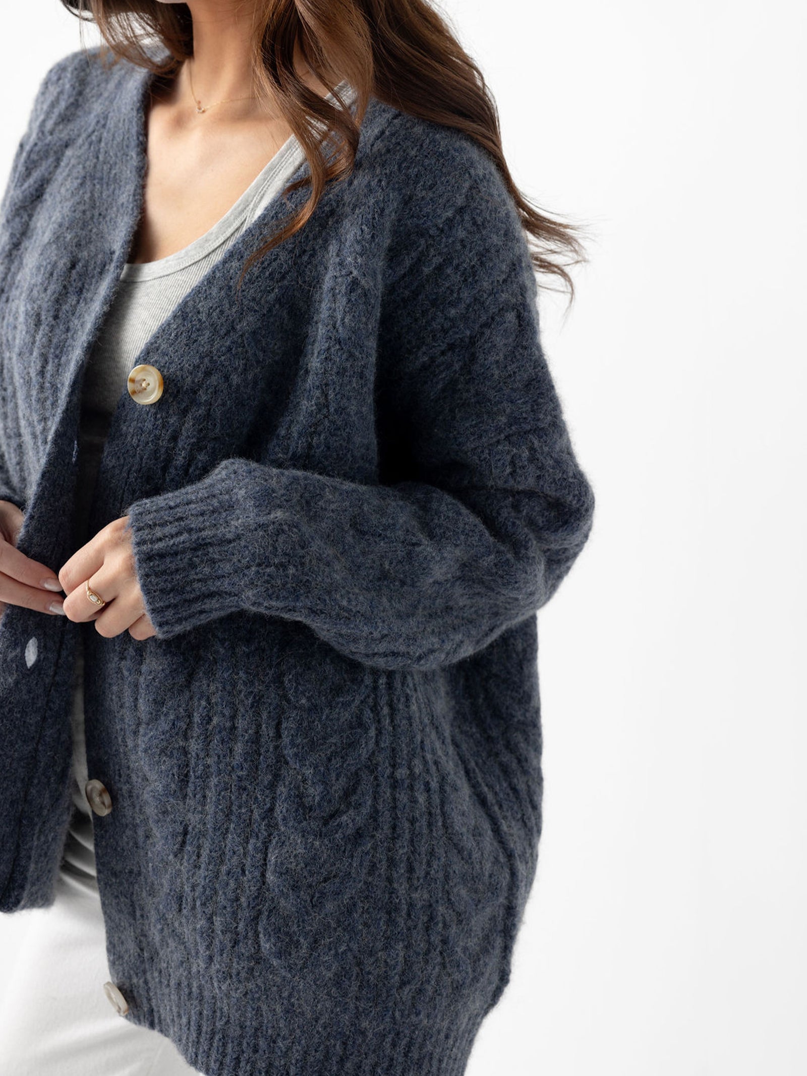 Close up of indigo cardigan on woman with white background 