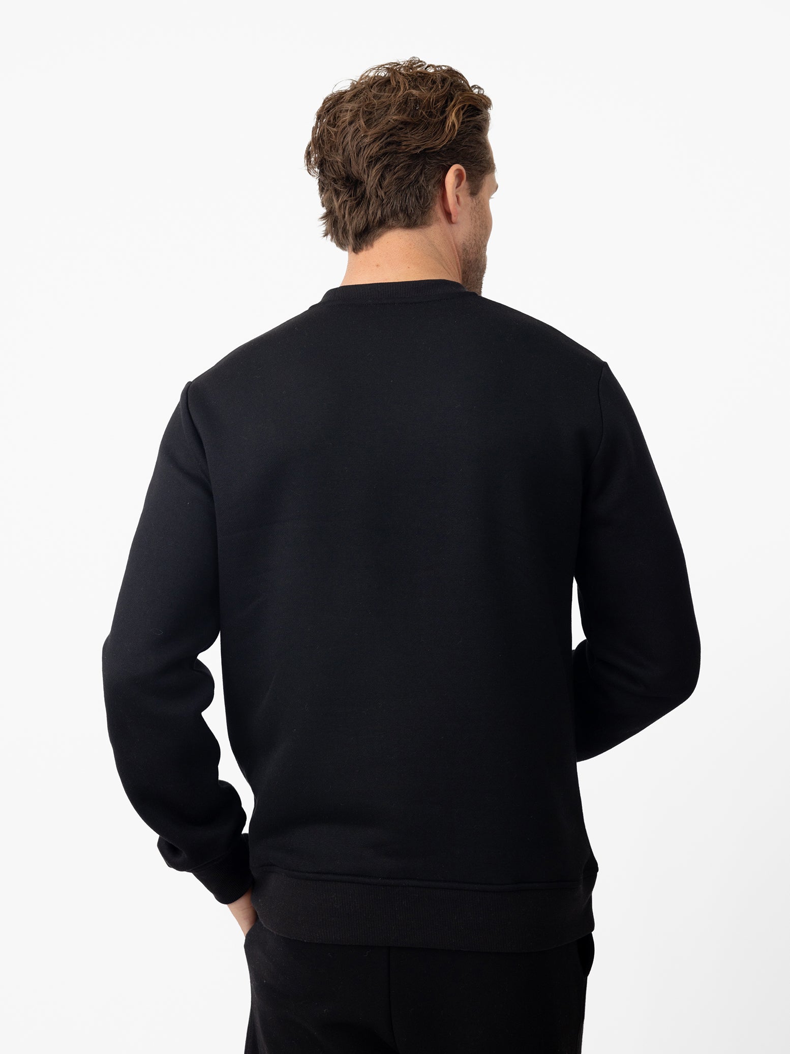 Back of man wearing black cityscape crewneck 