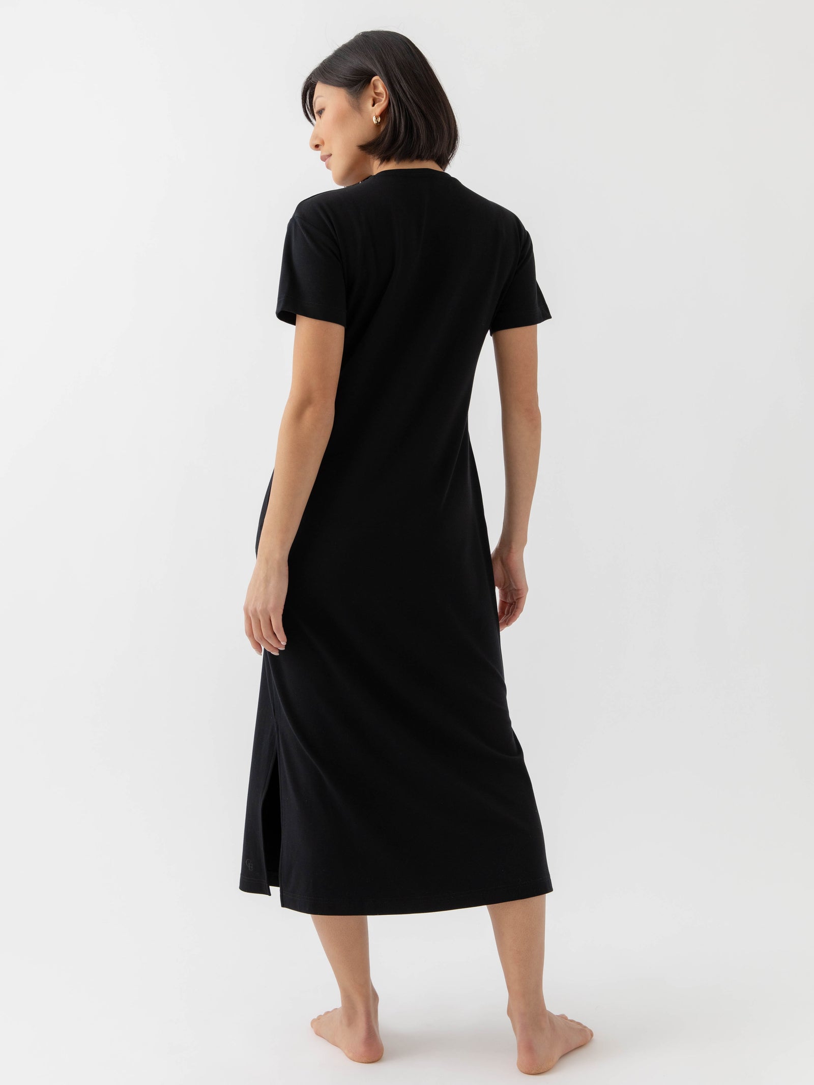 Black Bamboo Midi Dress modeled by a woman. The photo was taken in a high contrast setting, showing off the colors and lines of the dress. 
