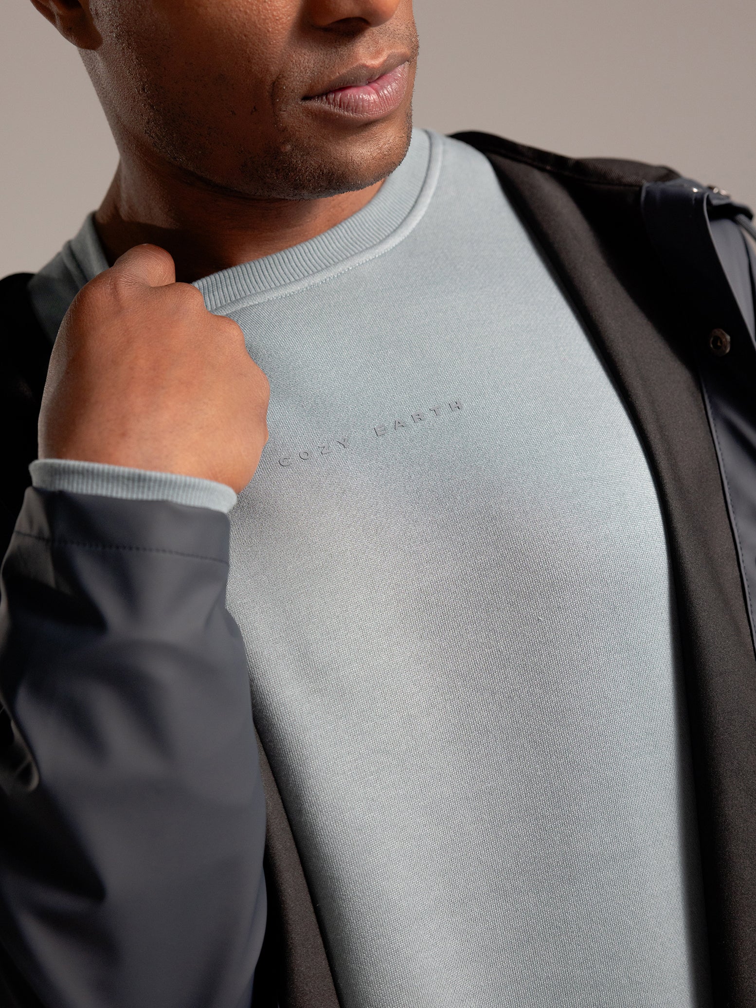 Man wearing Smokey Blue cityscape crewneck with grey background 