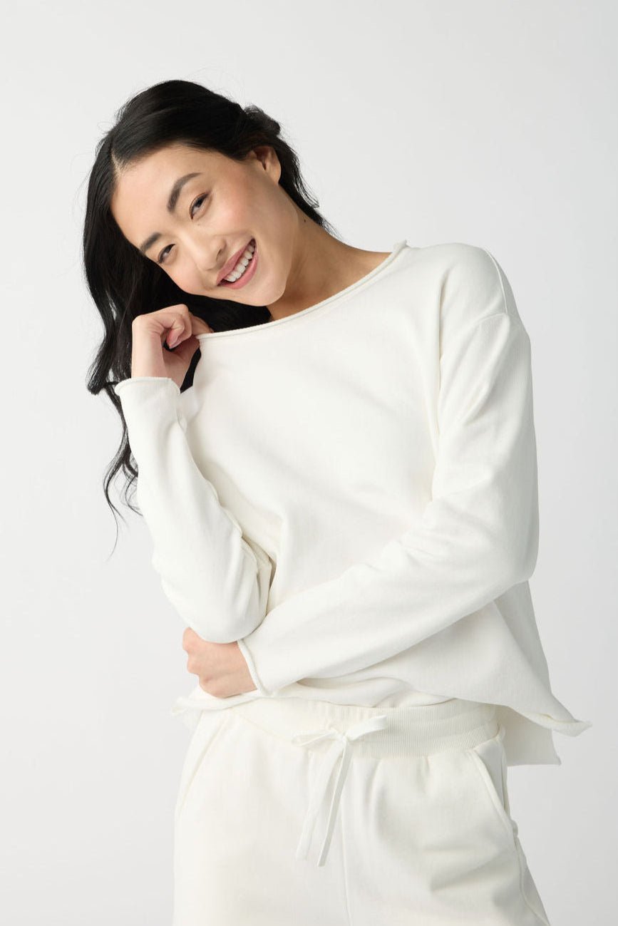 A dark haired woman wears Cozy Earth Women's Chelsea Pullover in Bone. 