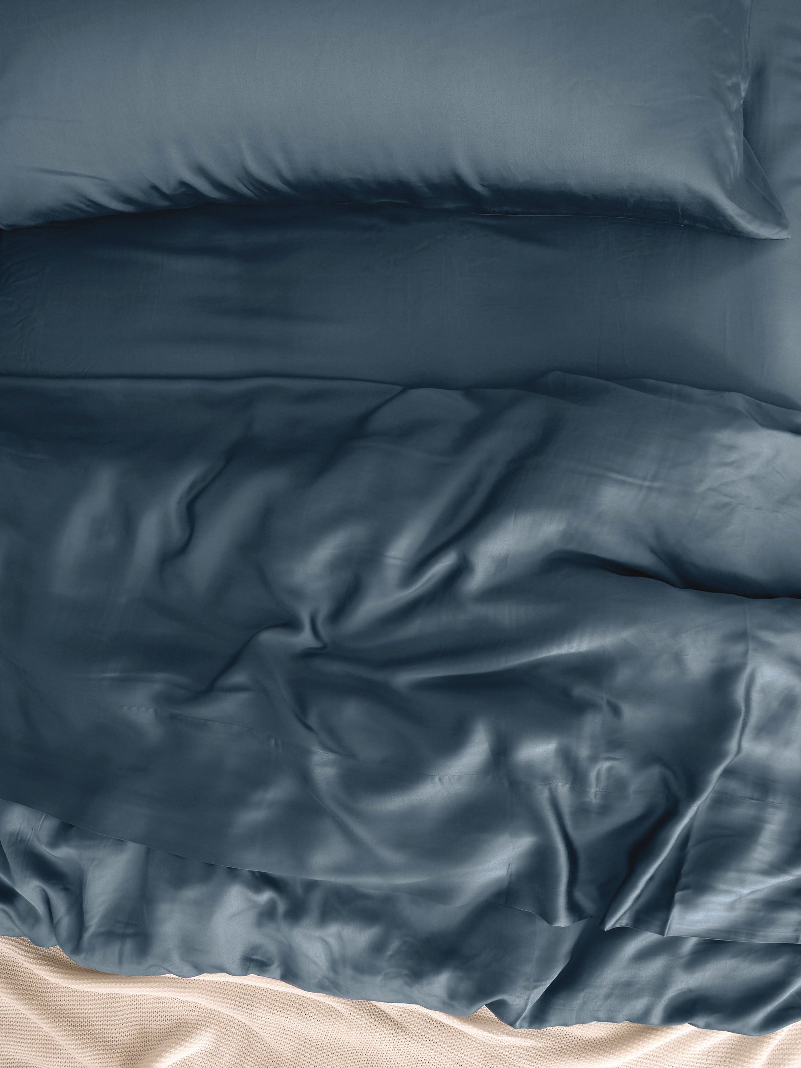 Close up of pacific blue bedding on an unmade bed 