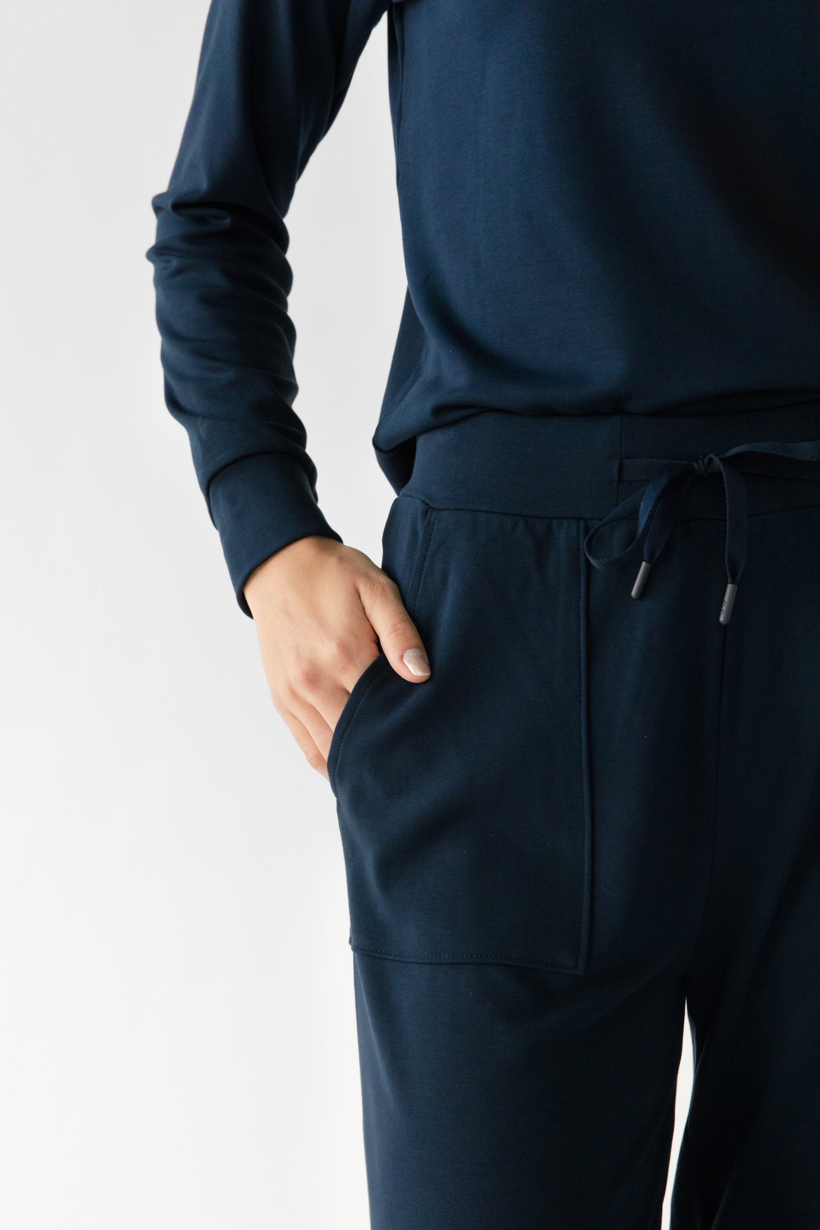 Navy Bamboo Wide Leg Patch Pocket Pant modeled by a woman. The photo was taken in a high contrast setting, showing off the colors and lines of the pajamas. 